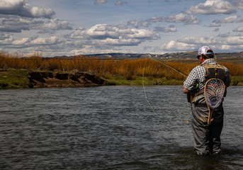 A man fly fishing on a western trout stream in the spring.