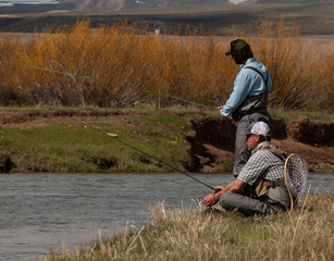 Naklejka na ściany i meble A father and son fly fishing on a wild trout stream.