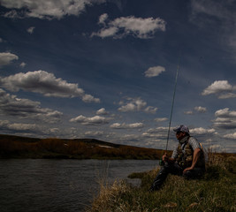 A man alone  fly fishing on a wild trout stream.