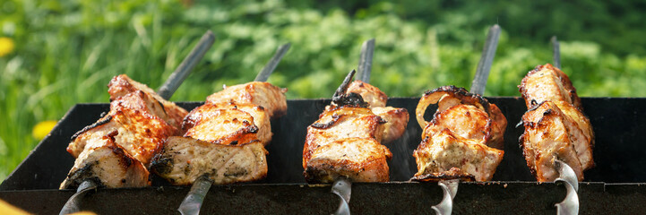 meat on spits roasts on handmade garden grill closeup