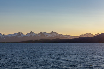 A mystical fjord in Norway with mountains and fog hanging over the water in polar day. midnight sun, selective focus