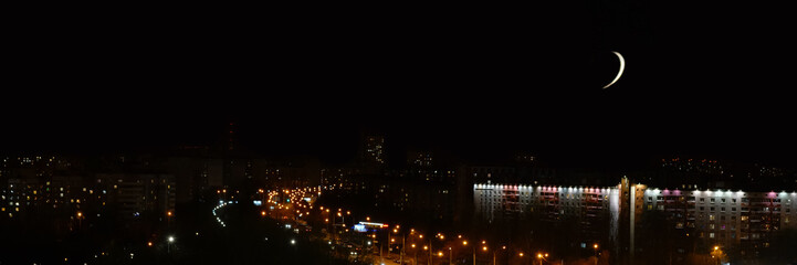 Fototapeta na wymiar clear black sky with white moon over night city street