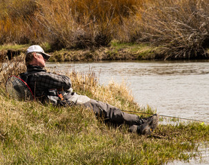 Naklejka premium A mature male taking a stream side nap during a fly fishing outing.