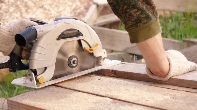 a man saws boards with a circular saw