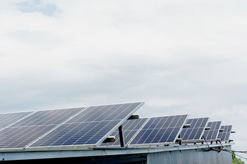 Solar panels stands in row on the roof . Free electricity for home. Sustainability of planet. Green energy. Solar cells power plant business. Ecological clean energy. Blue panels on the ground.
