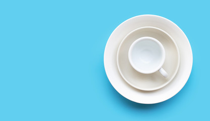 Stack of dish, bowl and cup on blue background.