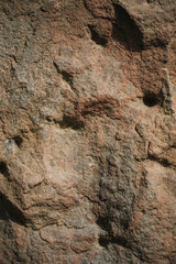 Background stone texture with different patterns, cracks, protrusions shadows and holes. Image with a natural pattern of the surface of the rock with unique patterns