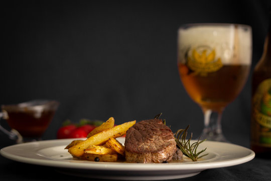 dish with fried potato, filett, tomatoes and beer