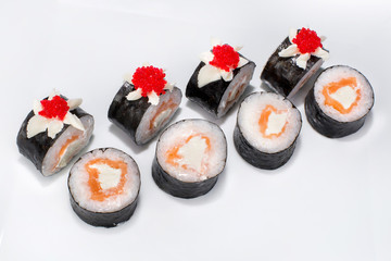Japanese roll of rice, nori seaweed, salmon, cream cheese and tobiko on a white plate