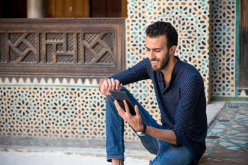 Young Muslim man working on tablet