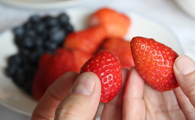 Mangiare fragole rosse e mirtilli viola - bontà