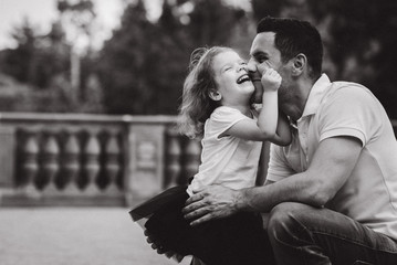 Handsome young father and beautiful mother in sunny summer nature playing with their cute small childrens