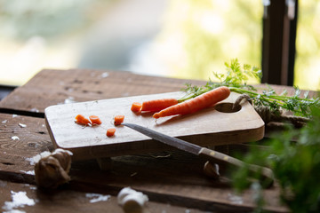 Fototapeta na wymiar Carrots on wooden desk near window at kitchen