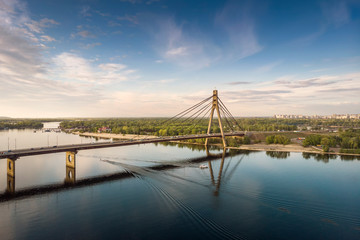 Aerial view of Pivnichny Bridge in Kyiv and; background city view and boats on the water.