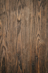 Brown natural organic wood texture with patterns. Background with different shapes, straight and curved lines, on the surface of a wooden board close-up.