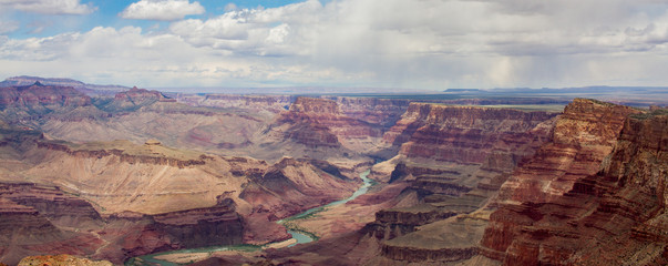 Panoramic landscape of Grand Canyon and Colorado river from desert view watchtower with storm in the distance