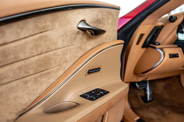 Beige car interior with black buttons on the door. Close-up. Horizontal orientation.