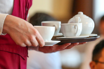 the waiter in the cafe brought customers tea