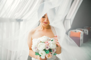 Portrait of stunning bride with long hair posing with great bouquet