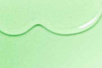 Beauty oil serum drop. Skincare liquid gel texture. Cosmetic spa treatment product on green color background