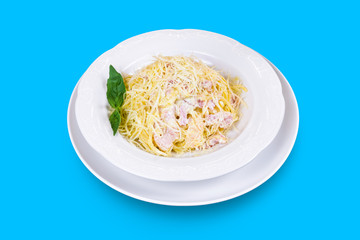 Delicious Italian spaghetti Carbonara with cheese, bacon and fresh mint isolated on blue background