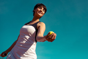 jeune femme lançant une balle de tennis pour faire un service
