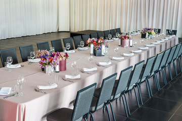 a long table served with dishes and flowers. horizontal frame