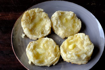 English muffins on grey plate with melted butter