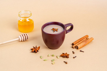 Traditional indian tea. Masala tea in a dark clay cup with ingredients.