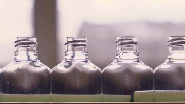 Empty plastic bottles for sanitizers are moving along the conveyor belt at the factory for the production of personal protective equipment.