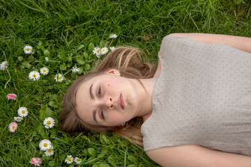 Resting girl on a bright green lawn.