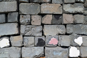 Stack of used and damaged grey сoncrete blocks for construction. Background and еexture.
