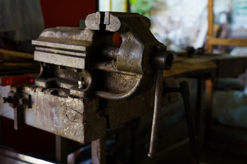 Old rusty steel clamp vise iron metal tool in the workshop workbench in day