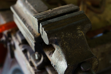 Old rusty steel clamp vise iron metal tool in the workshop workbench in day top view