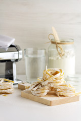Homemade pasta and ingredients on a light background