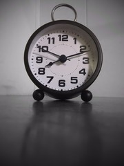 A waker clock on the table in black and white view