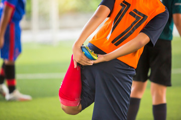 Fototapeta premium Soccer player is stretching their hands to catch their feet.