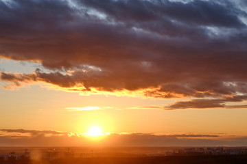 Clouds over building city during the orange sunset