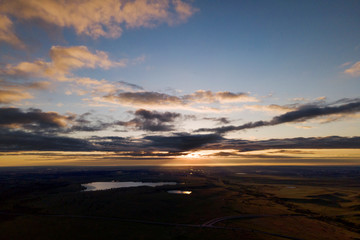 Fototapeta na wymiar sunrise with clouds over distant lake
