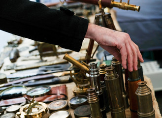 Closeup of a man's arm reaching for an item at a flea market.