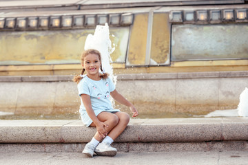 Obraz na płótnie Canvas Russia, Moscow, 2019 August 31 -Portrait of a lovely little girl in the city over fountain.