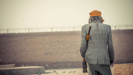 Backside of a man in checkered clothing with scarf