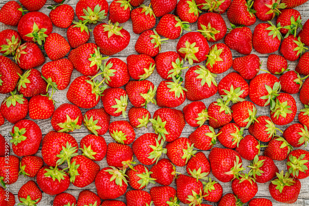 Poster Fresh German strawberries in carton paper boxes on wooden table, top view.  Red strawberry berrees harvesting concept