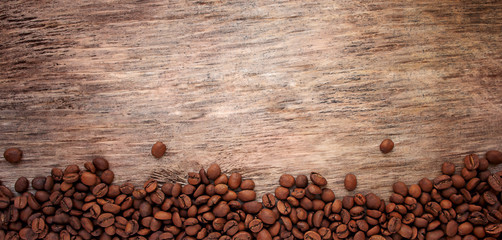Coffee beans on a textured wooden background banner