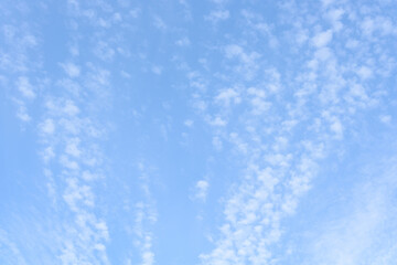 Early morning blue sky with light white cloud streaks
