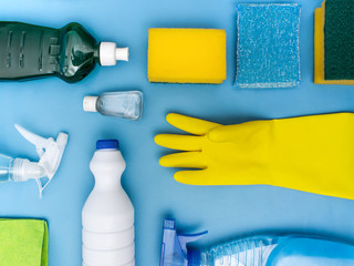household cleaning products on blue background on flat lay