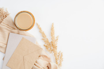 Autumn composition with romantic letters, cup of coffee, beige blanket and dry flowers on white background. Flat lay, top view, copy space. Hygge or boho style, autumn fall concept.
