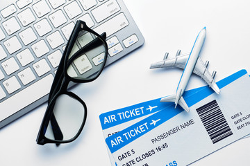 Vacation concept - glasses, airline tickets, airplane with a keyboard with a top view
