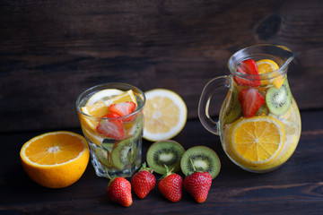 Lemonade of citrus, kiwi and strawberry. Tasty summer refreshing drink, infused water with fruits and berries. Homemade vitamin tropical beverage