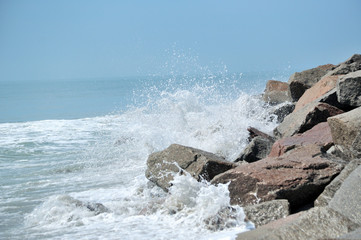 Waves breaking on large rocks on the shore